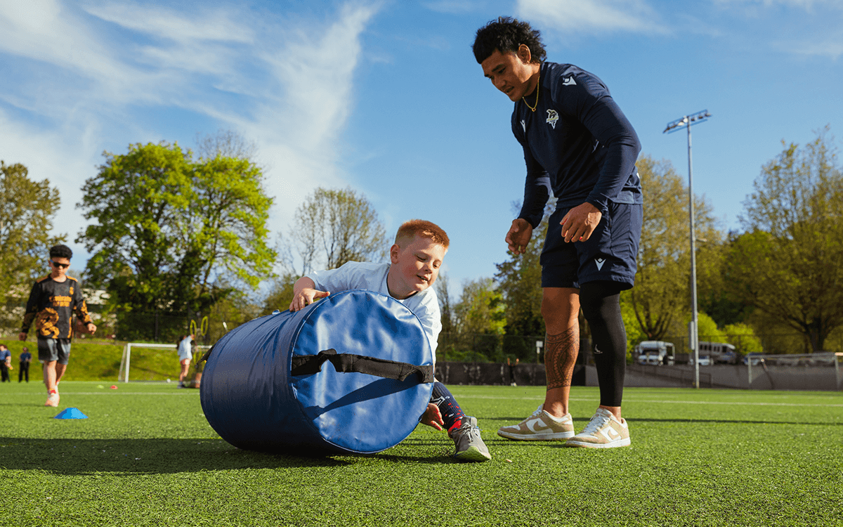 Seawolves players lead a rugby session with young people in the community.