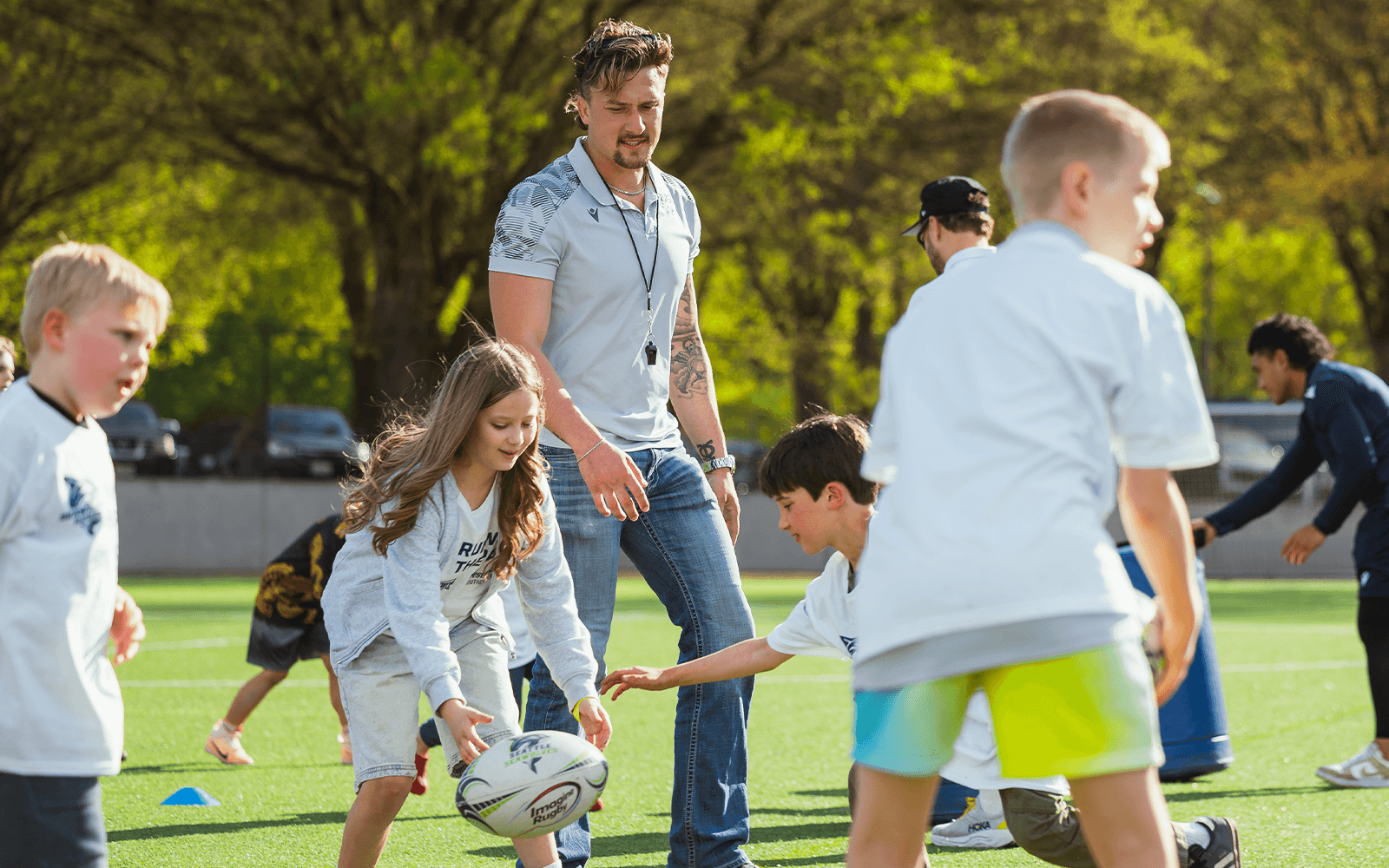 Young athletes practice rugby passing during a Seattle Seawolves youth camp.